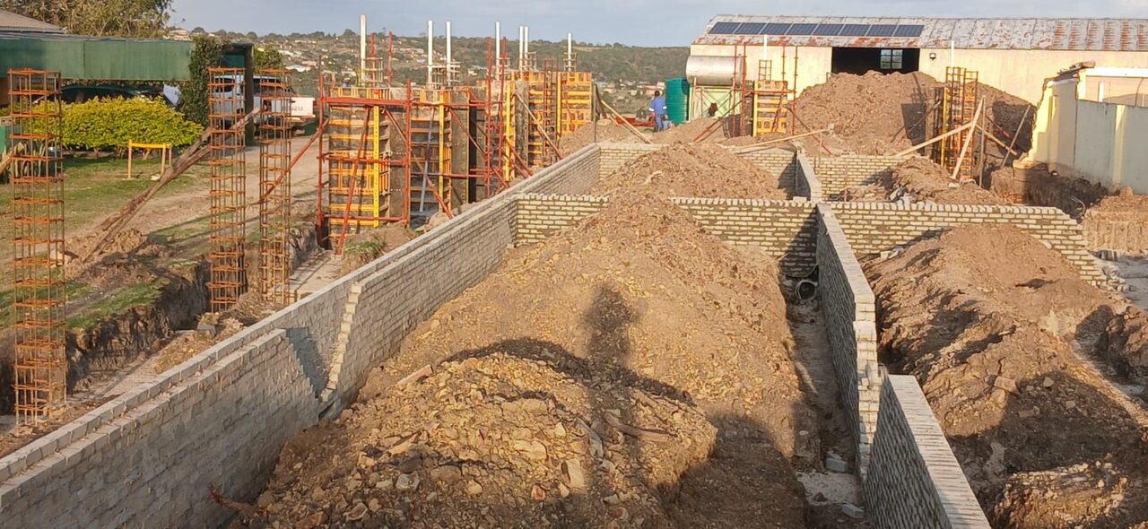 Brick retaining walls under construction alongside Peri column formwork system on an Eastern Cape building site