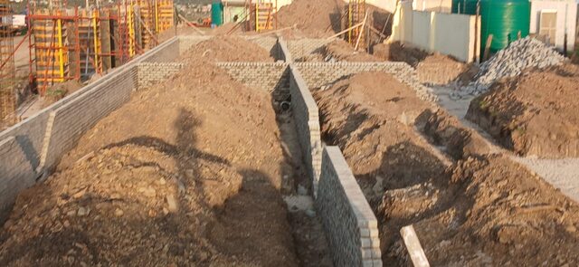 Second view of brick retaining channel walls with Peri column formwork system behind, on civil works site
