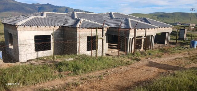 Front elevation of single-storey home with tiled roof and column portico in late afternoon light, Eastern Cape